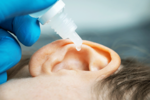 Child getting ears cleaned with peroxide